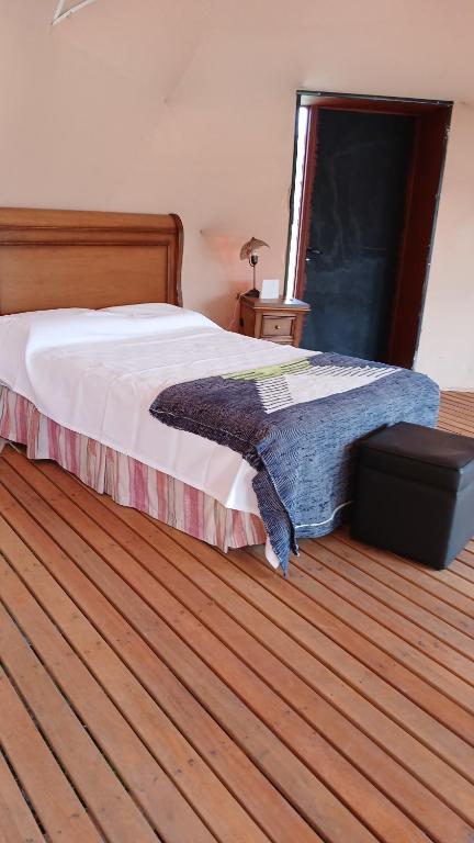 a bedroom with a bed and a wooden floor at Domo Naranja in Miramar