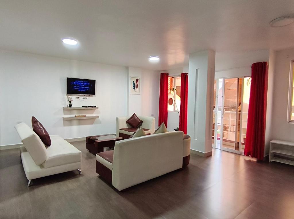 a living room with two chairs and a tv at Casa Gaviota Dorada in Baños