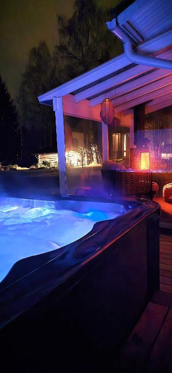 a swimming pool at night with purple lights at Villa It's Arctic Magic! in Rovaniemi