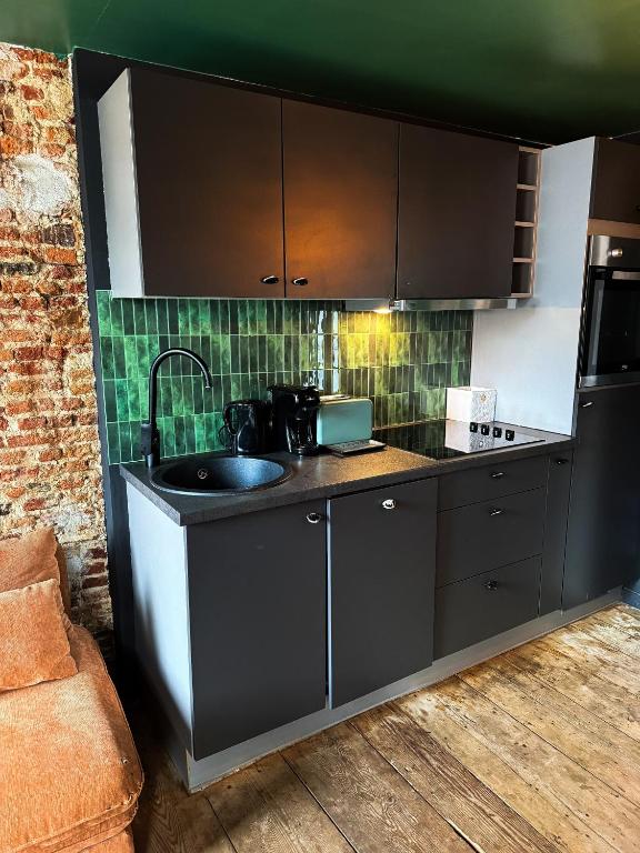 a kitchen with a sink and a counter top at Cosy Boudoir Suites - 4p in Antwerp