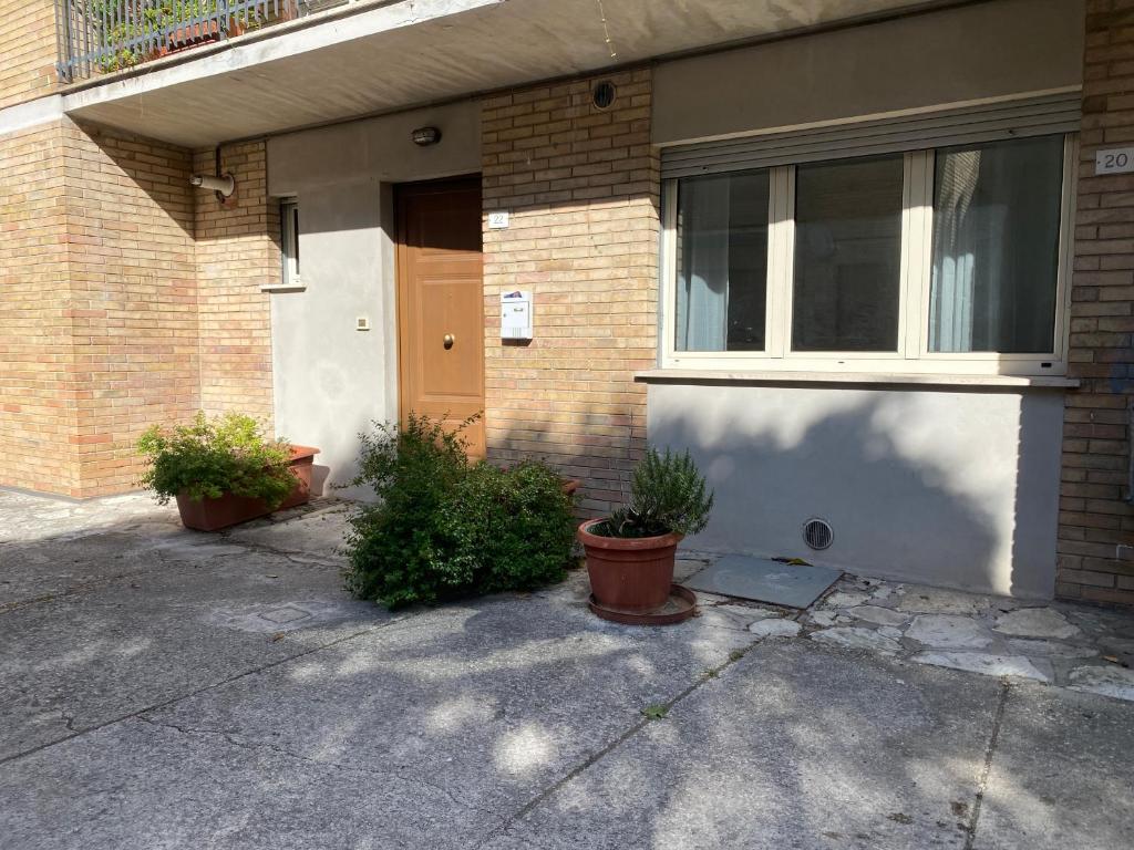 une maison avec deux plantes en pot devant elle dans l'établissement My Bright, à Gubbio