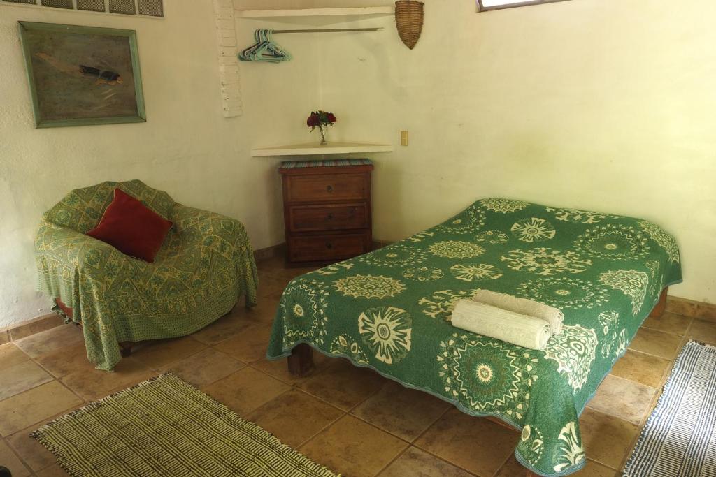 a bedroom with a bed and a chair in a room at Casa Poesía Sayulita in Sayulita
