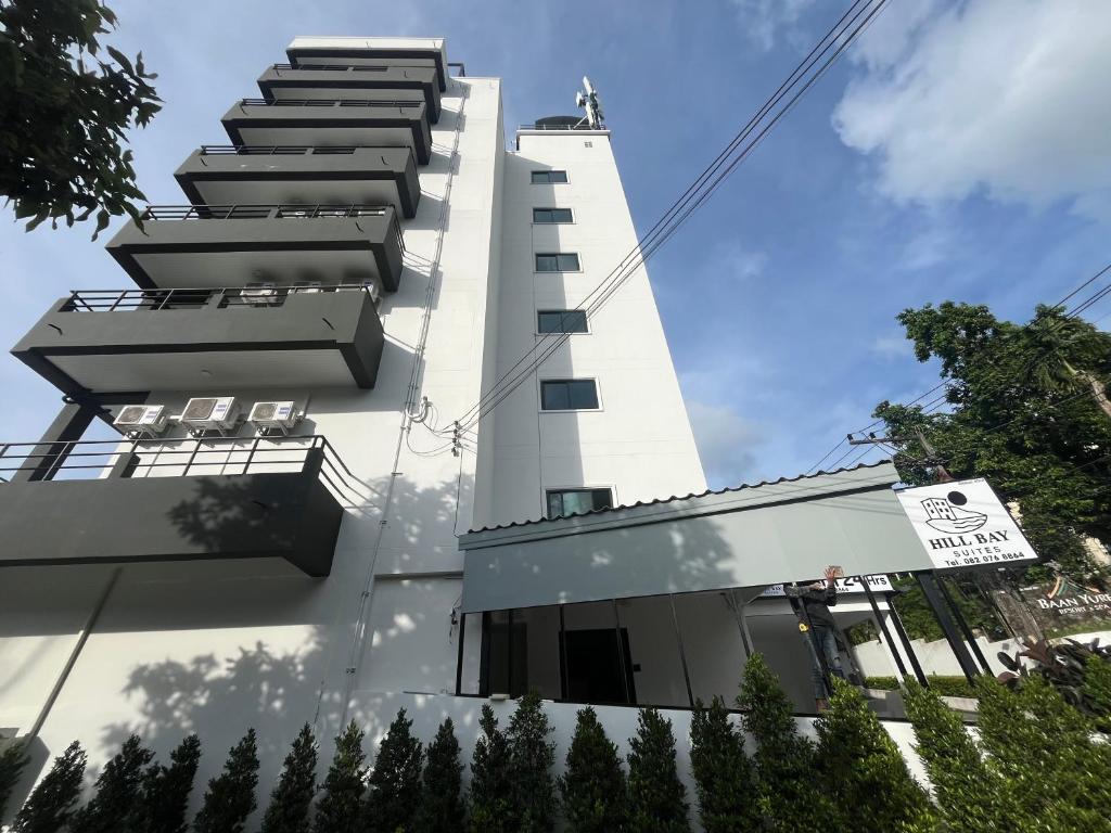 a white building with stairs on the side of it at Hill Bay Suites Hotel in Patong Beach