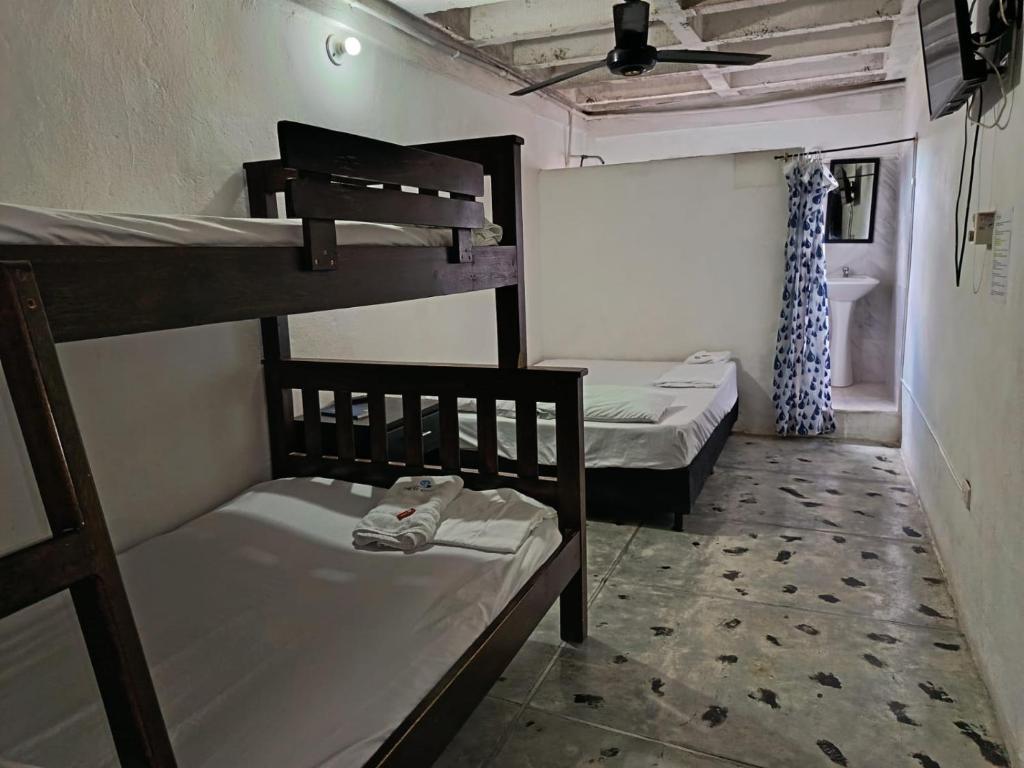 a room with two bunk beds and a bathroom at Hotel Efata in Apartadó