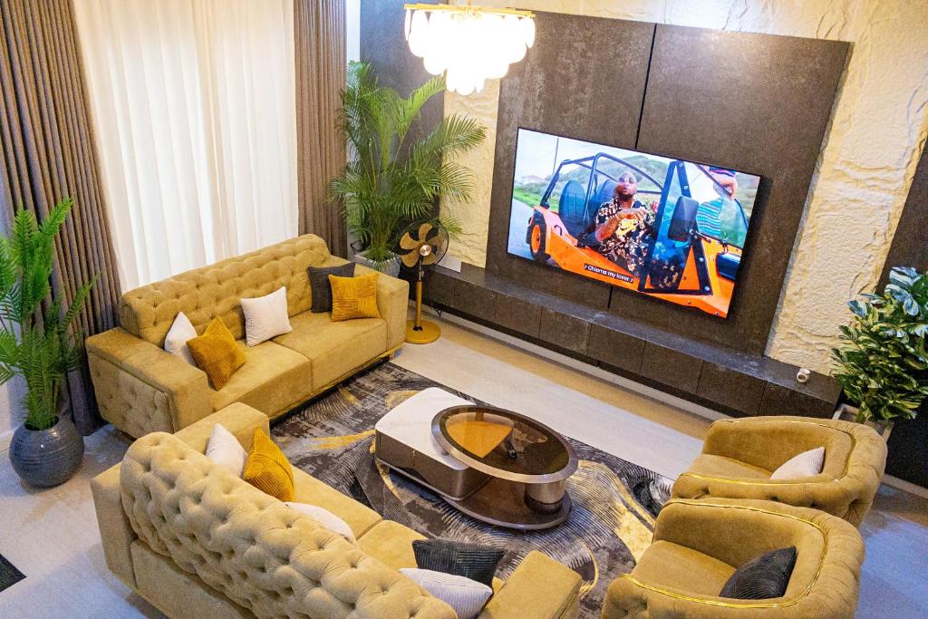 a living room with couches and a flat screen tv at D'Vista Apartments in Ikota