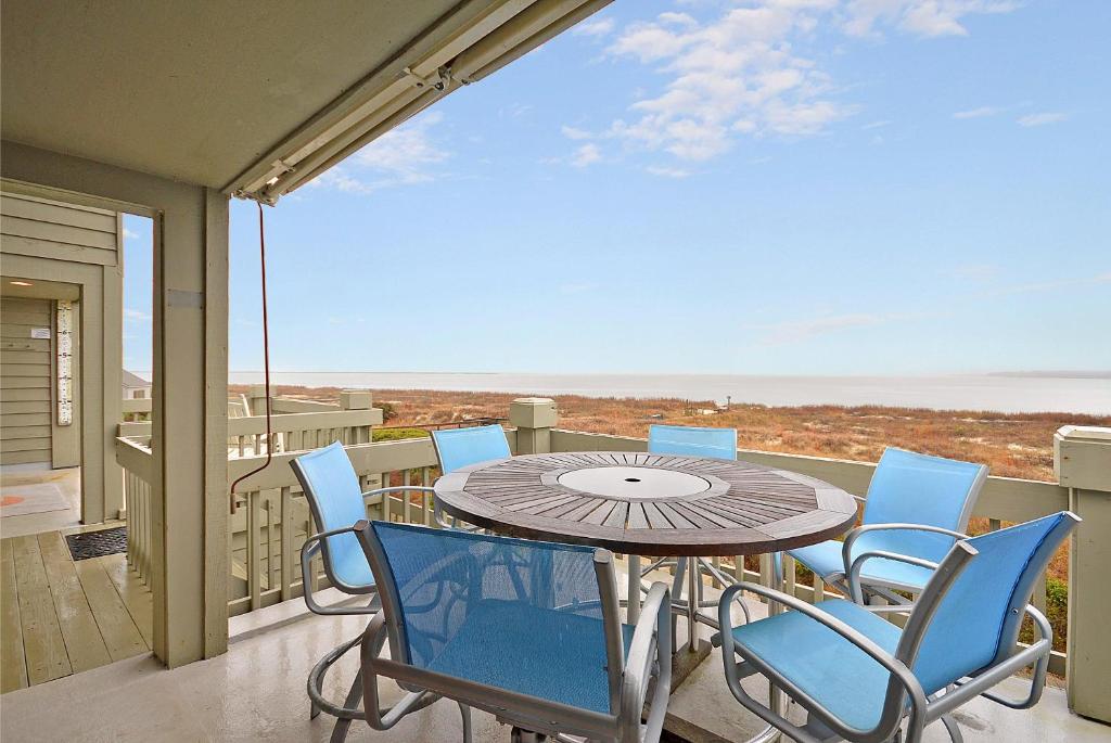 a patio with a table and chairs on a balcony at PW1310: 1310 Pelican Watch in Seabrook Island