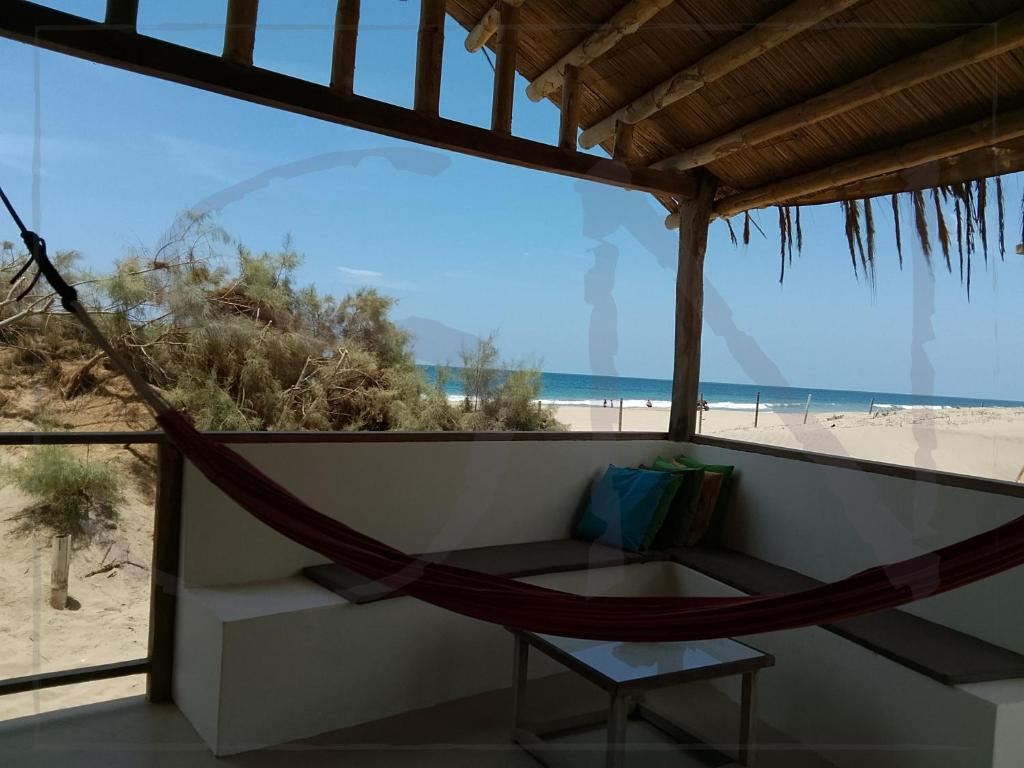 a hammock on a balcony overlooking the beach at Seaside Nord in Máncora