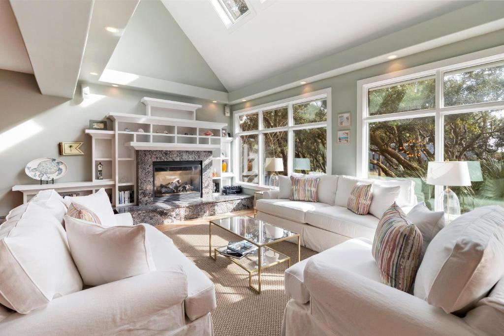 Una sala de estar con muebles blancos y chimenea. en SS52: 52 Surfsong, en Kiawah Island