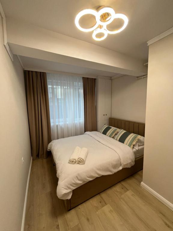 a bedroom with a bed with two slippers on it at Apartament Iulius Mall Cluj in Cluj-Napoca