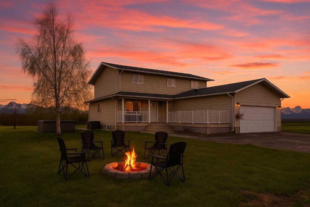a fire pit in the yard in front of a house at Hot-tub, Games Room, Walk-in Sauna, 7 BM, 15 mins to Waterton in Mountain View