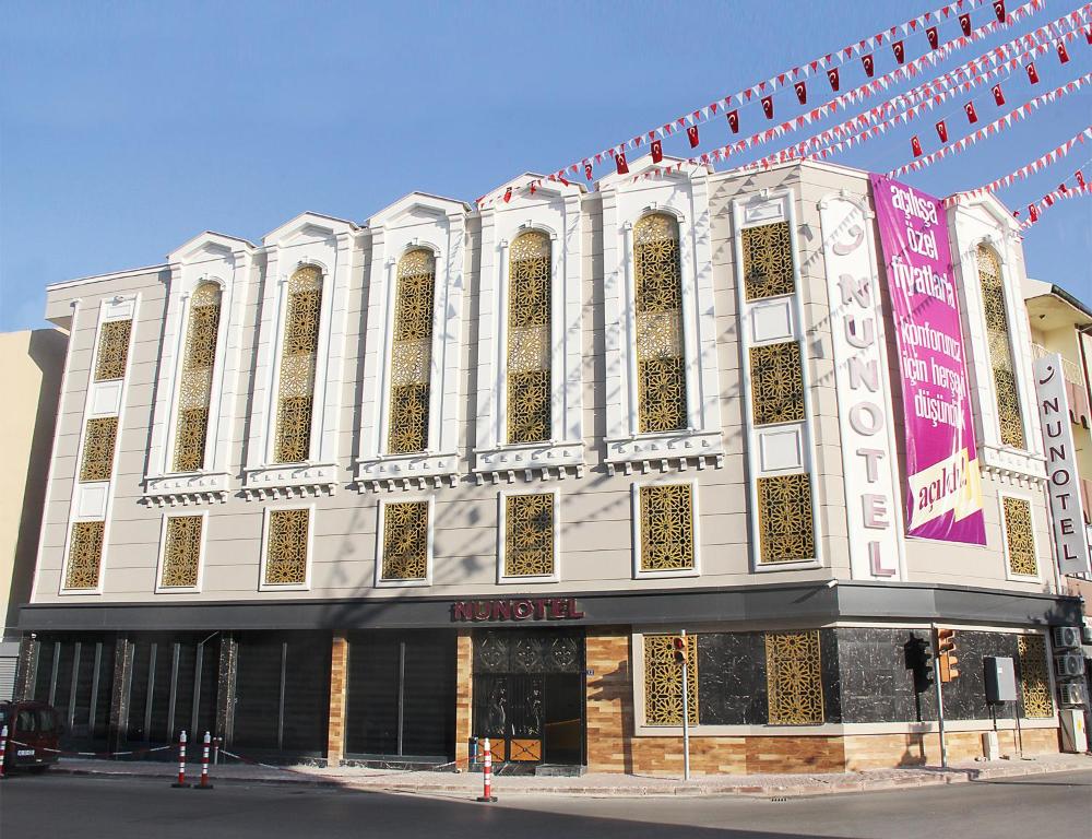 un grand bâtiment au coin d'une rue dans l'établissement Nun Hotel, à Konya