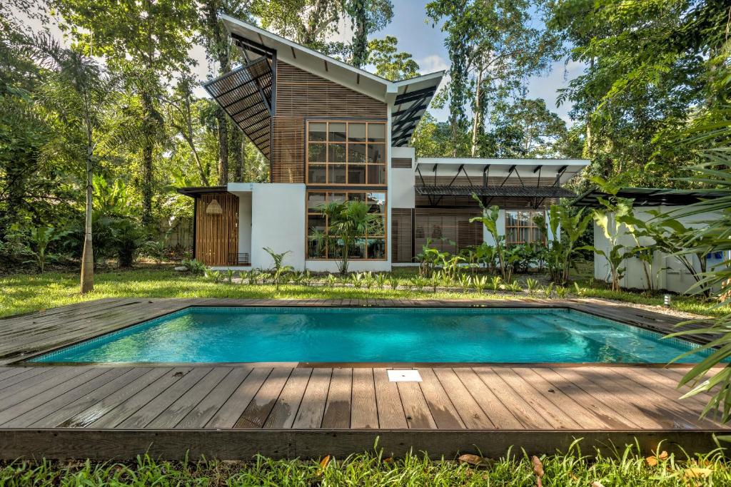 une maison avec une piscine et une terrasse en bois dans l'établissement Porto Alegre Resort, à Punta Uva