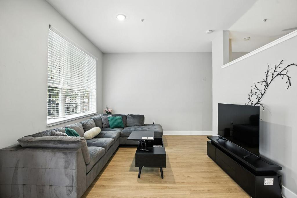 a living room with a couch and a tv at Towson Elite Apartment in Towson