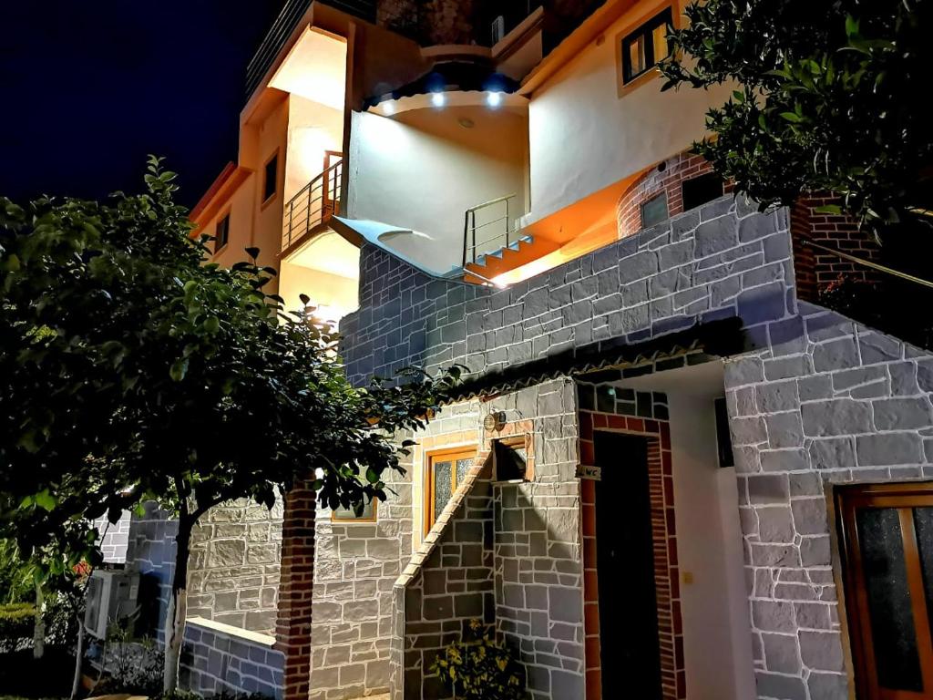 un bâtiment en briques avec un escalier dessus la nuit dans l'établissement Hotel Continental, à Ksamil