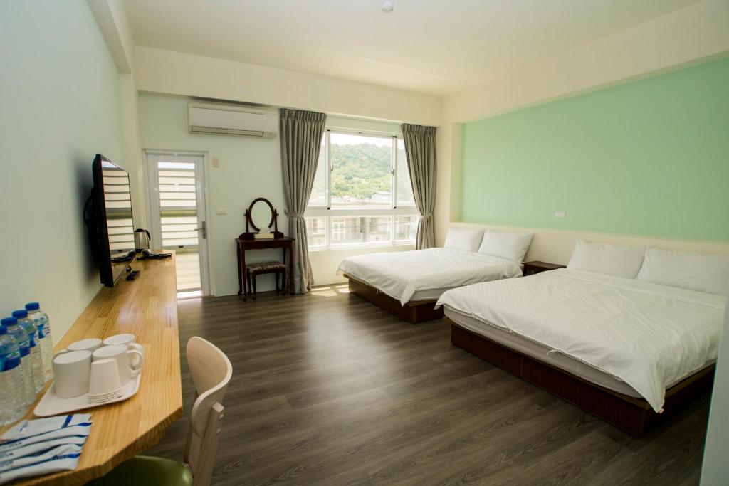 台東市的住宿－享棧民宿，酒店客房设有两张床、一张桌子和一张桌子。