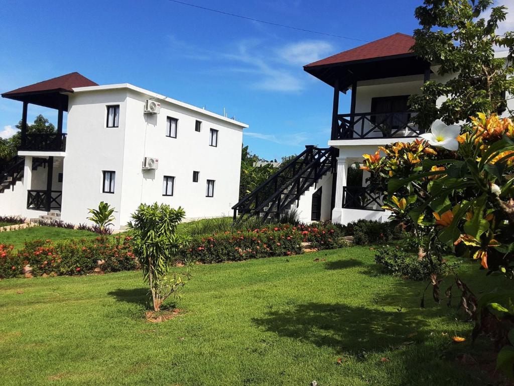 a large white building with a grass yard at Villas Reynoso, Near La Playita Beach in Las Galeras Samaná in Las Galeras