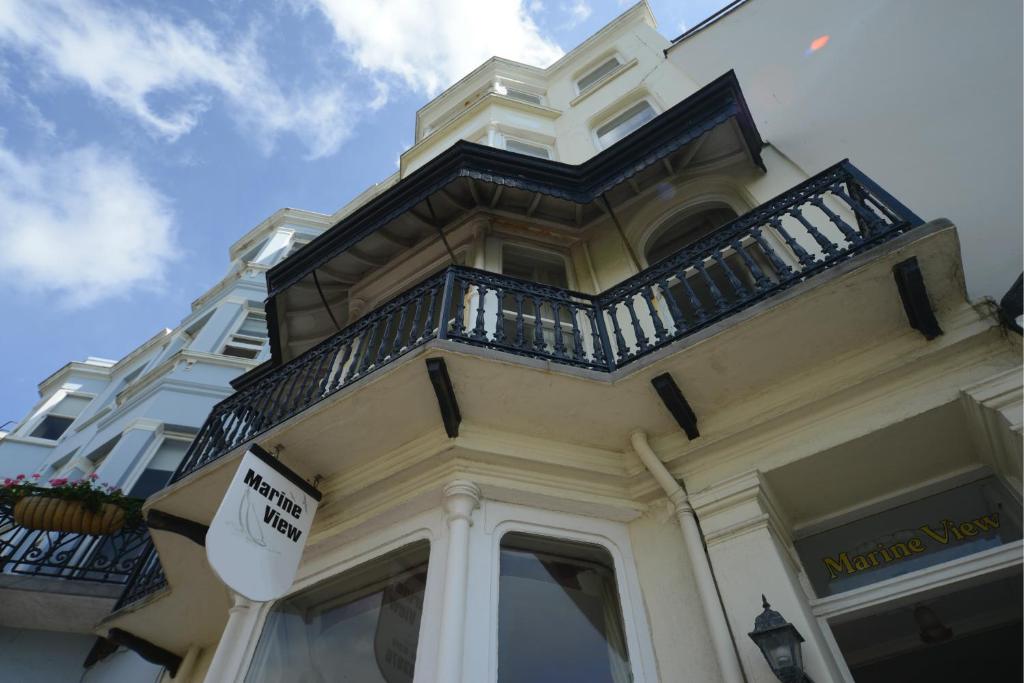 a white building with two windows and a balcony at Marine View in Brighton & Hove