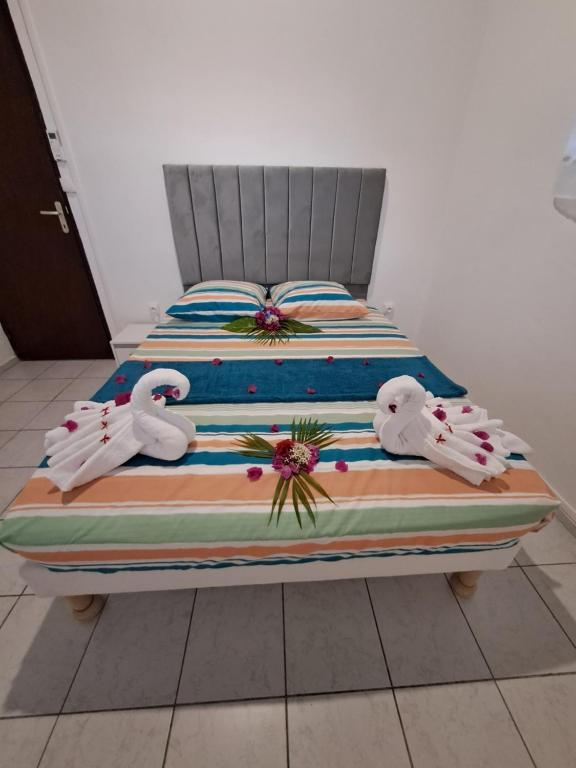 a bed with two white swans on it at Kaz'Agatha in Sainte-Anne