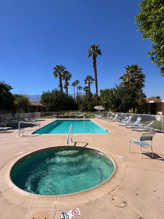 a small swimming pool in a resort with palm trees at Charming & Cozy 2-Bedroom in the Heart of Cathedral City! in Cathedral City