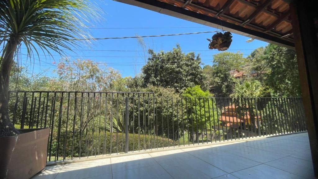 a balcony with a fence and a palm tree at Casa no centro in Miguel Pereira