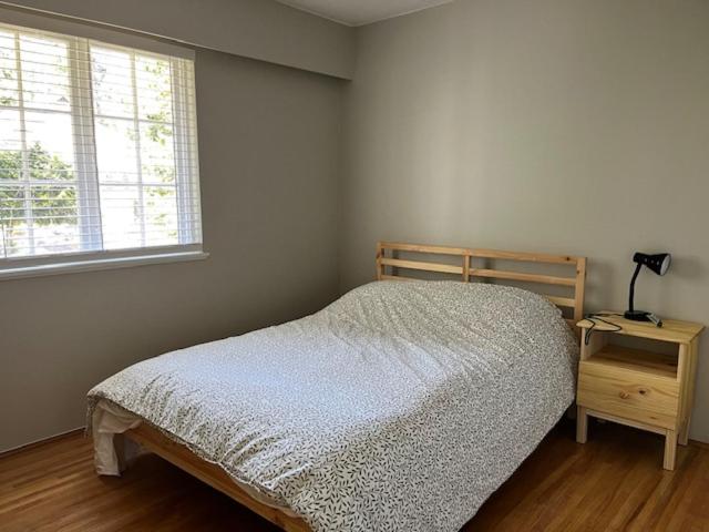 a bedroom with a bed and a window and a table at Edgewood Road in North Vancouver