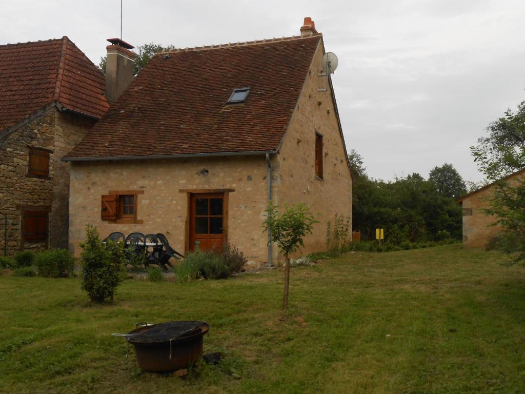a house with a wheelbarrow in front of it at Maison de Caractère Rénovée avec Jardin, Terrasse, et Proche du Château Guillaume - FR-1-591-131 in Lignac
