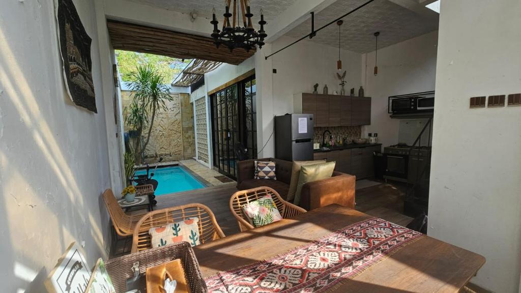 a kitchen and living room with a table and a pool at Vila Raima SYARIAH in Gresik