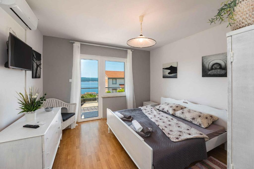 a bedroom with a bed and a view of the ocean at Apartment in Crikvenica 41694 in Sopaljska