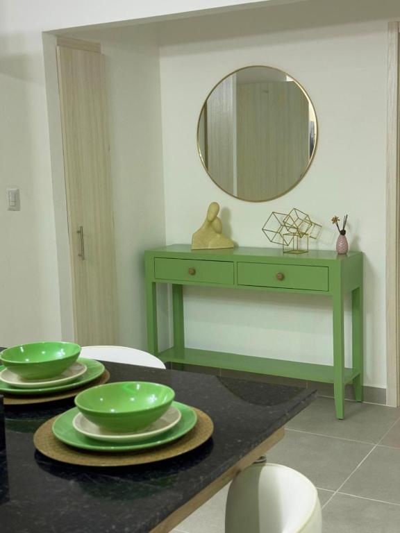Un tocador verde con platos y un espejo. en Serena Village E5 AP 203, en Punta Cana