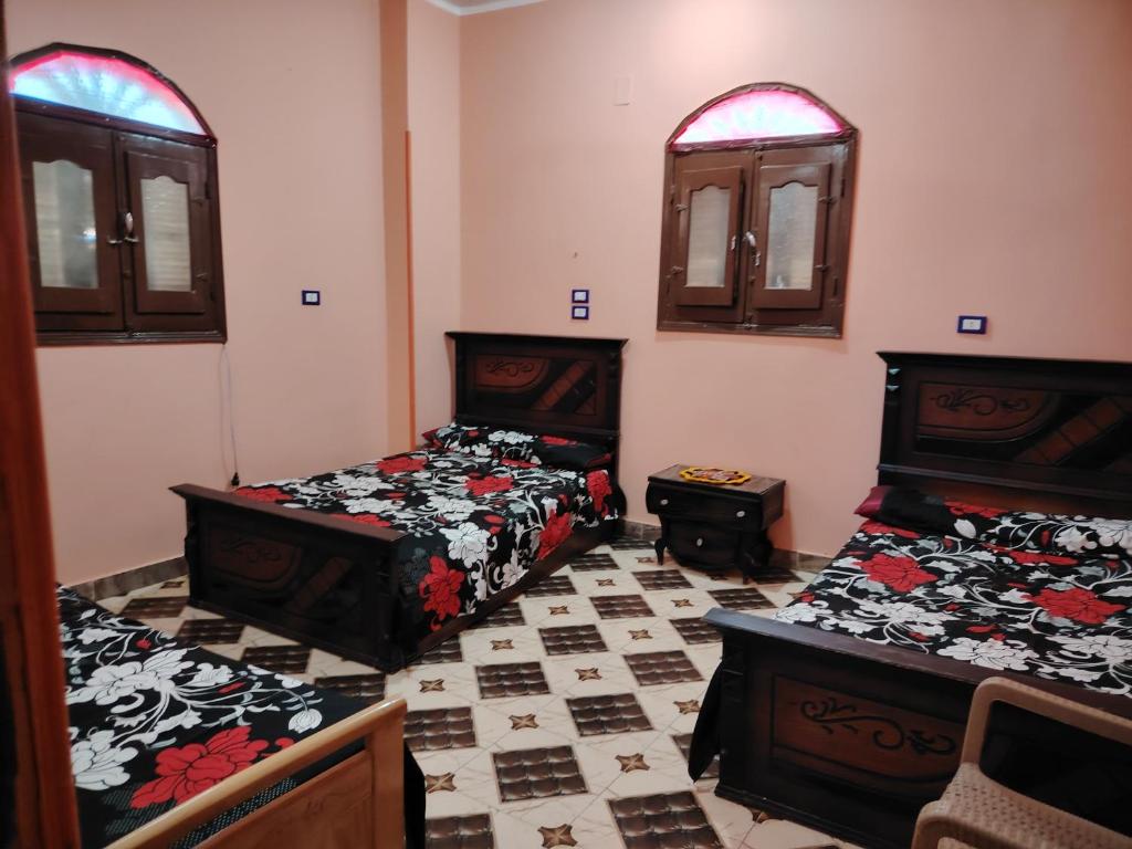a room with two beds and two windows at Venti house in Aswan