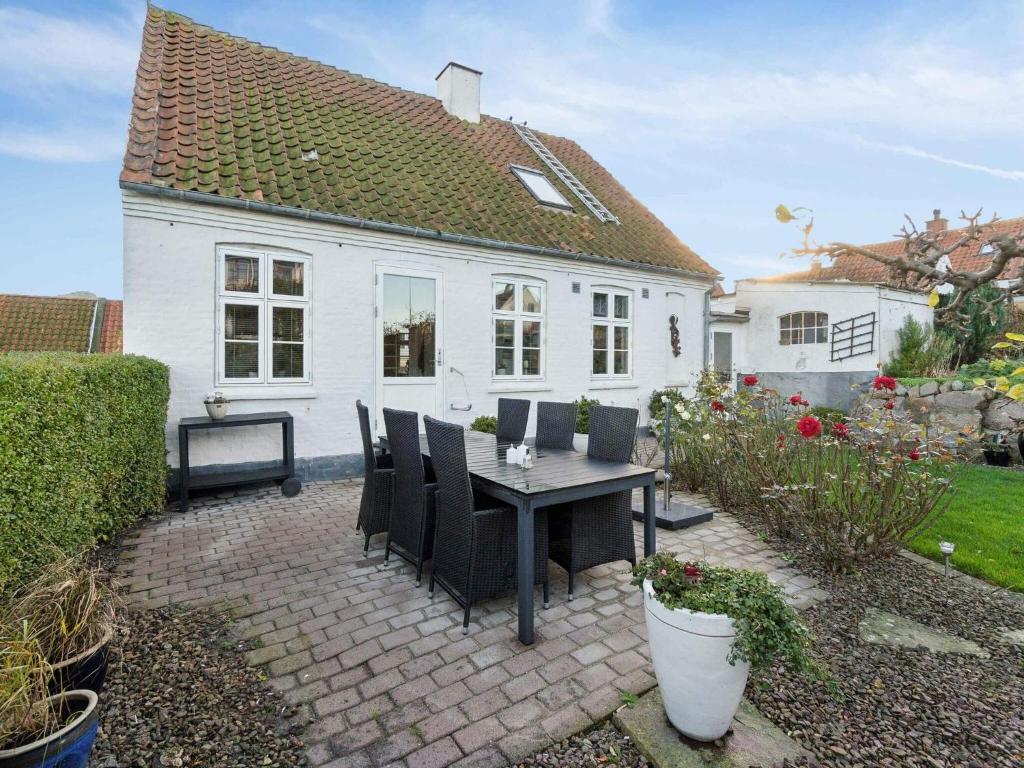 a table and chairs in front of a white house at 5 star holiday home in Allinge in Allinge