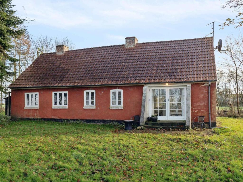 a red house with white windows and a yard at 5 star holiday home in Nykøbing M in Tæbring