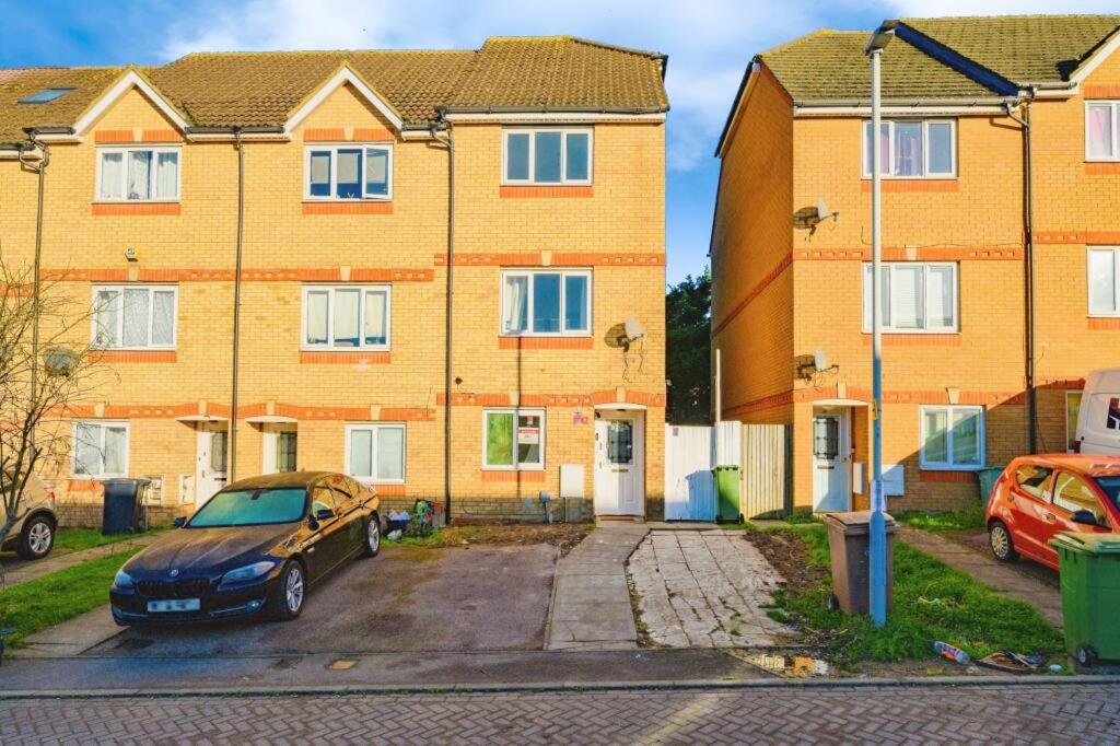 a car parked in a parking lot in front of a building at 3SIEE Homes in Luton