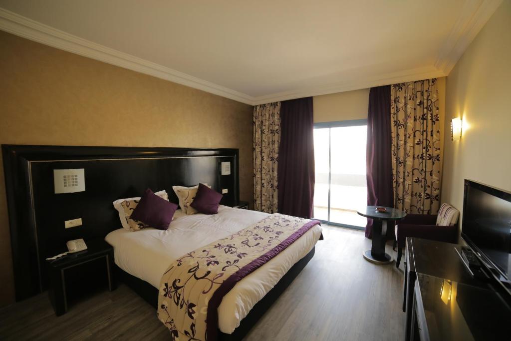 a hotel room with a bed and a window at Hotel Suisse in Casablanca