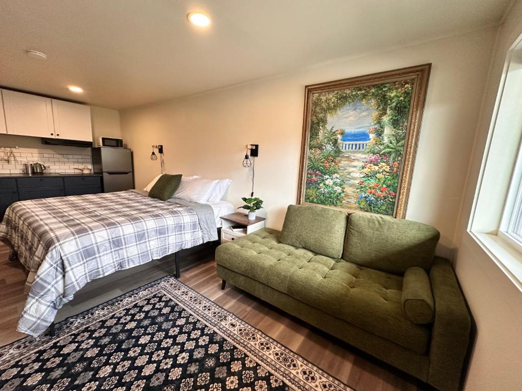a bedroom with a bed and a couch and a painting at Basecamp in Sagle