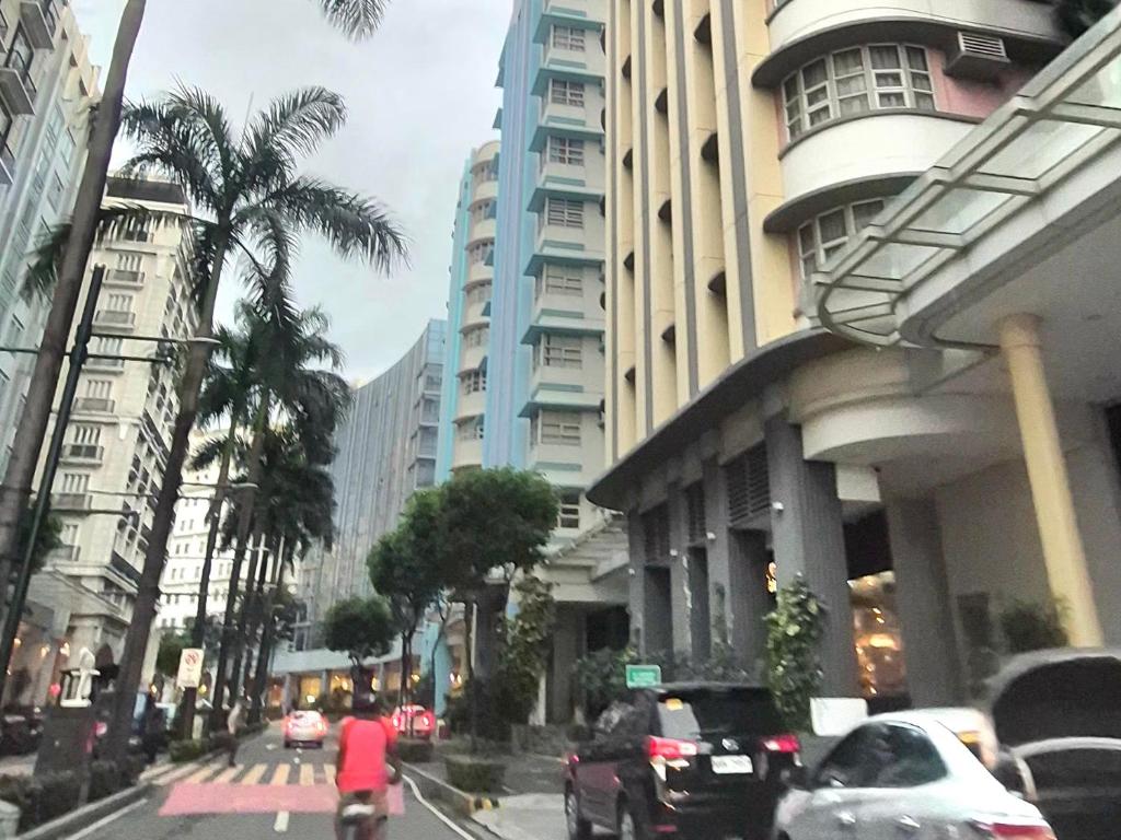 una persona que va en bicicleta por una calle de la ciudad con edificios en 101newport Condotel Near NAIA T3, en Manila