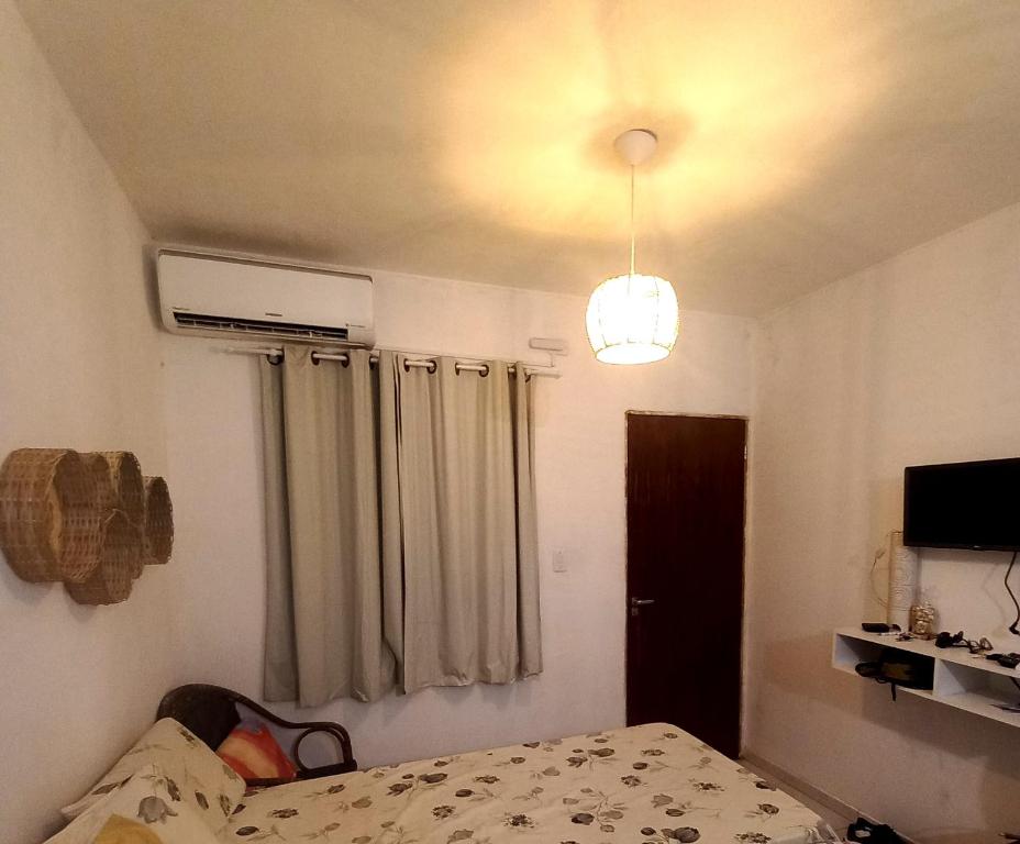 een slaapkamer met een bed en een licht bij Vila das Conchas - Estalagem in Japaratinga