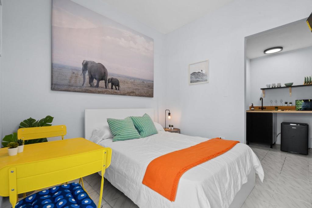 a bedroom with a large bed and a yellow desk at PR Rentals Ocean Park Beach Apartment 2 in San Juan