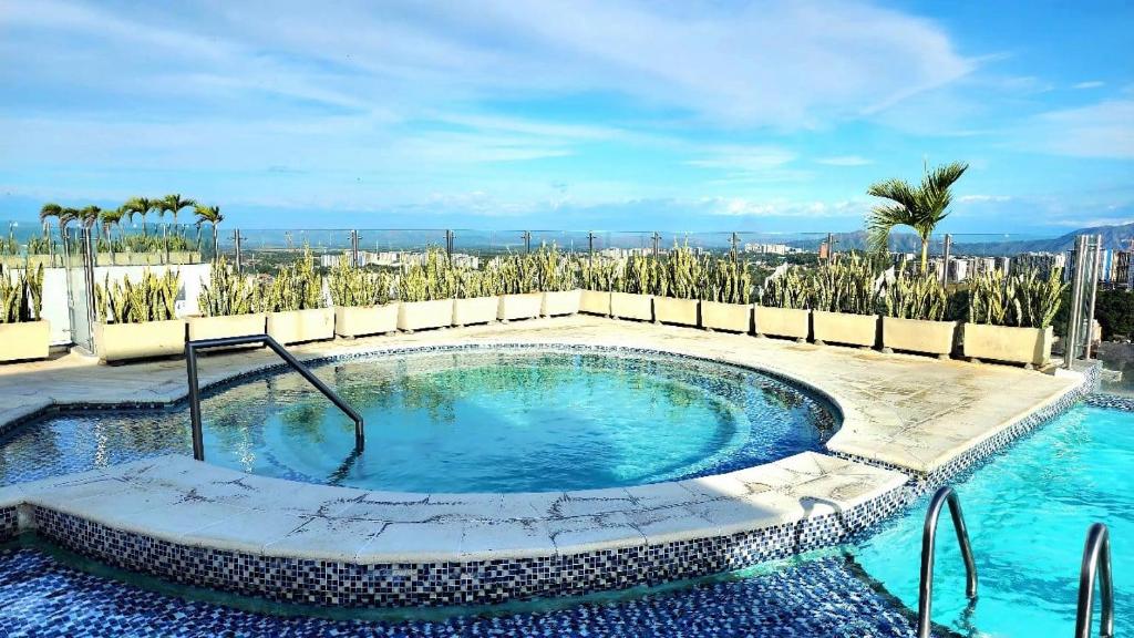 a swimming pool in a resort with palm trees at Moderno y amplio apartamento cerca a centros comerciales in Ibagué