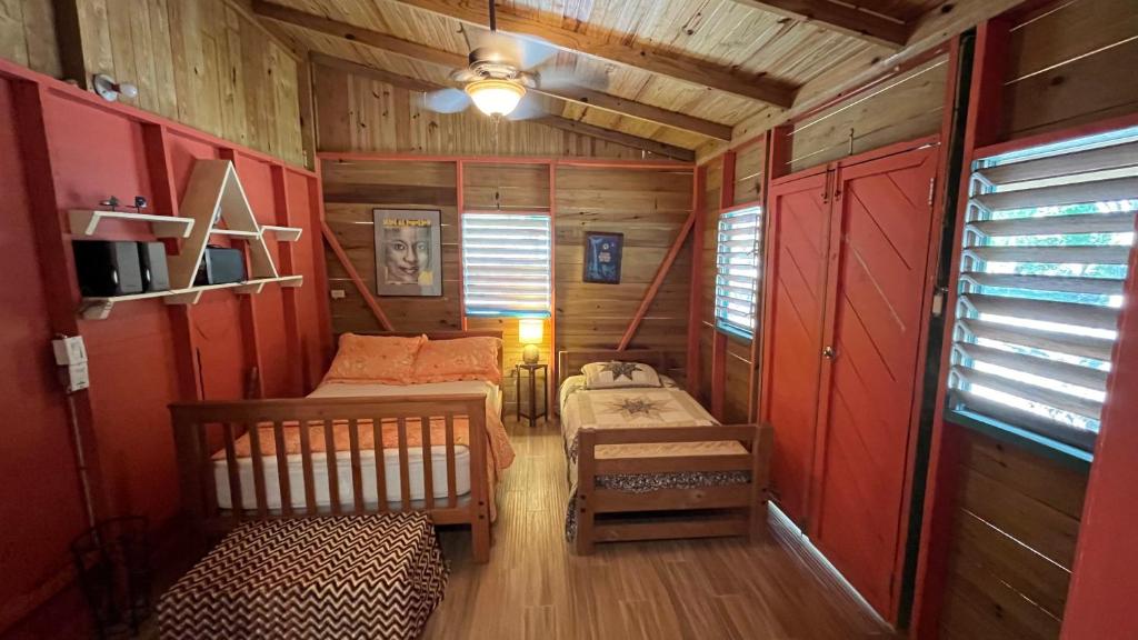 a small room with two beds in a cabin at La Casita at Ankobra Farm 