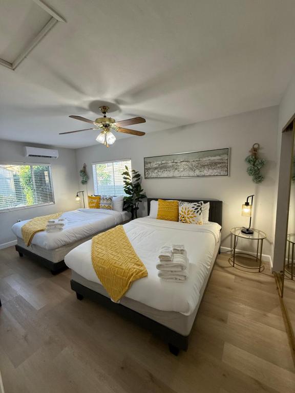 two beds in a bedroom with a ceiling fan at Relaxing Cozy Back House with Backyard in Upland