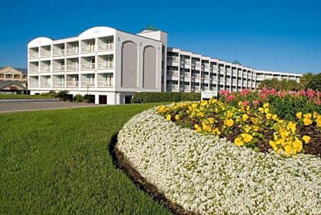 un gran edificio blanco con flores delante en Seawall Breeze One bedroom Condo in Galveston, en Galveston