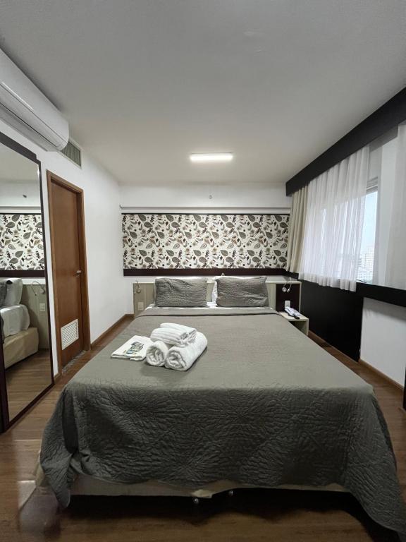 a bedroom with a large bed with towels on it at Hotel Mercu Beneficência Bela Vista Com Garagem 1203 in Sao Paulo