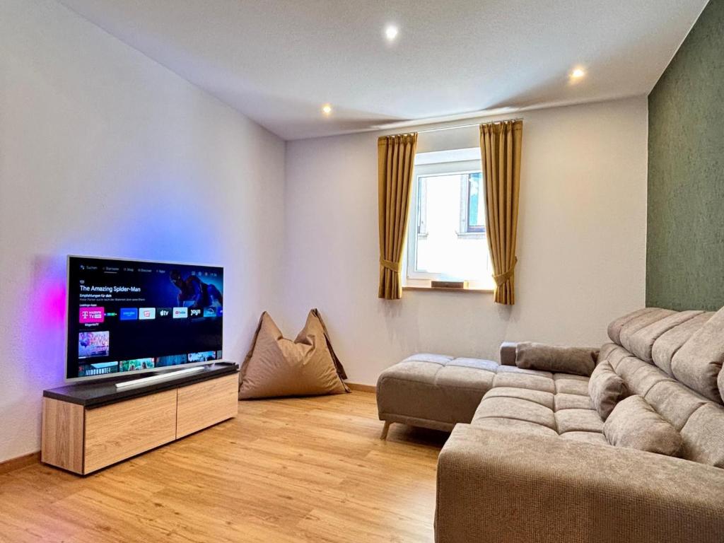 a living room with a couch and a flat screen tv at Ferienwohnung History in Herbolzheim nahe Zentrum in Herbolzheim