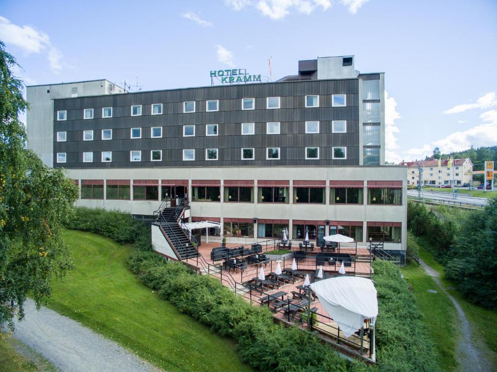 a hotel with tables and chairs in front of a building at First Hotell Kramm in Kramfors