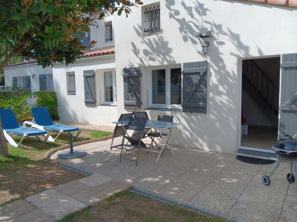 a patio with chairs and a table in front of a house at Charmante maison au calme près de la plage, jardinet privatif, 4 pers, animaux sur demande - FR-1-476-13 in La Faute-sur-Mer
