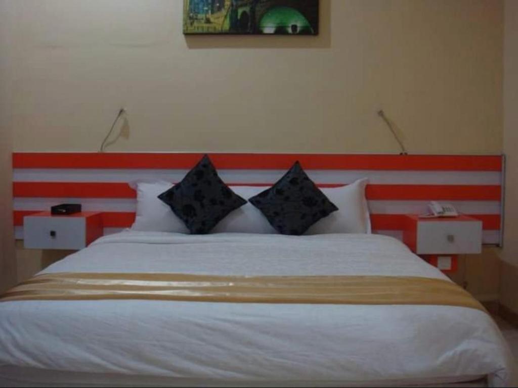 1 dormitorio con 1 cama con cabecero rojo y blanco en Mutiara Mansion Aparthotel, en Seminyak