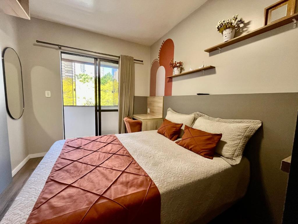 a bedroom with a large bed and a window at ApComplete in the center in Caxias do Sul