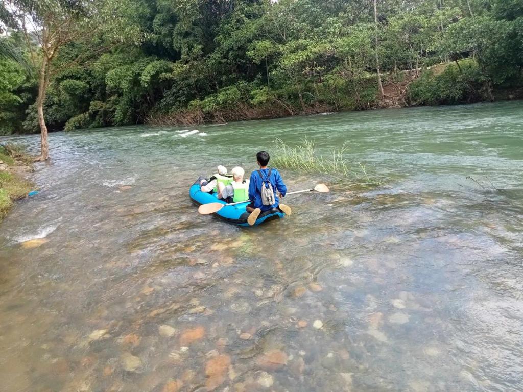 a man is sitting on a raft in a river at Khaosok Creek and Jungle Resort in Ban Song Phi Nong