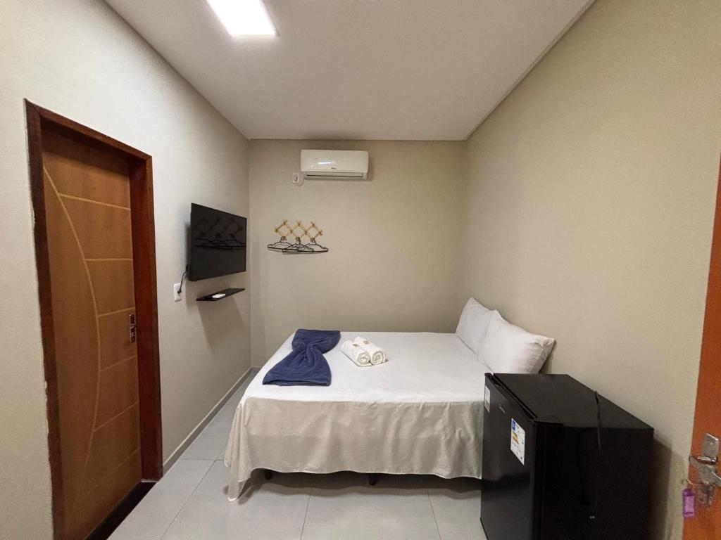 a small room with a bed and a television at Pousada Bela Lua in Piranhas